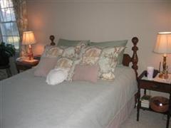 bedroom after: the wall color is a beige the duvet cover is a light blue-green for pillows the curtain fabric was used